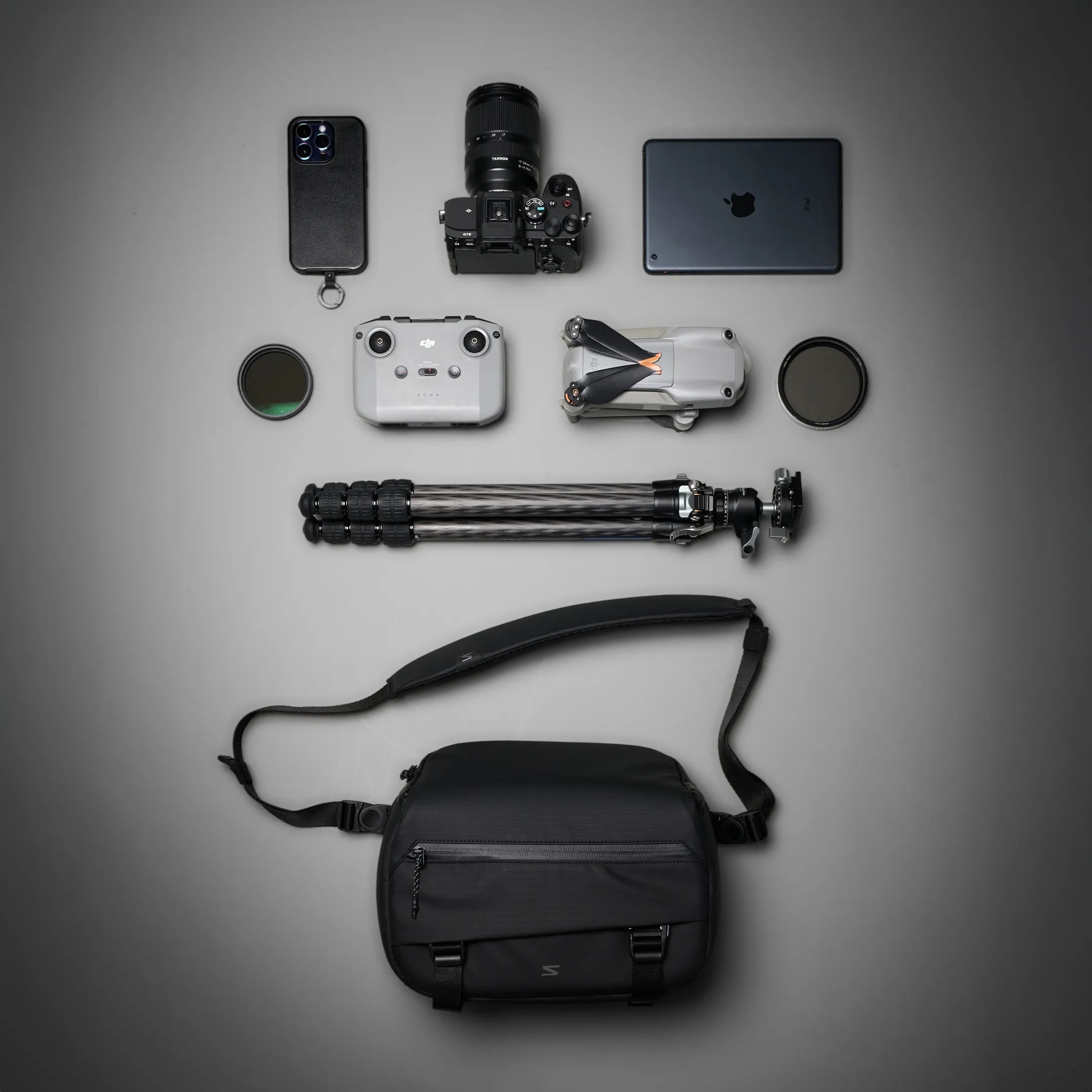 flat lay of camera gear and sling bag