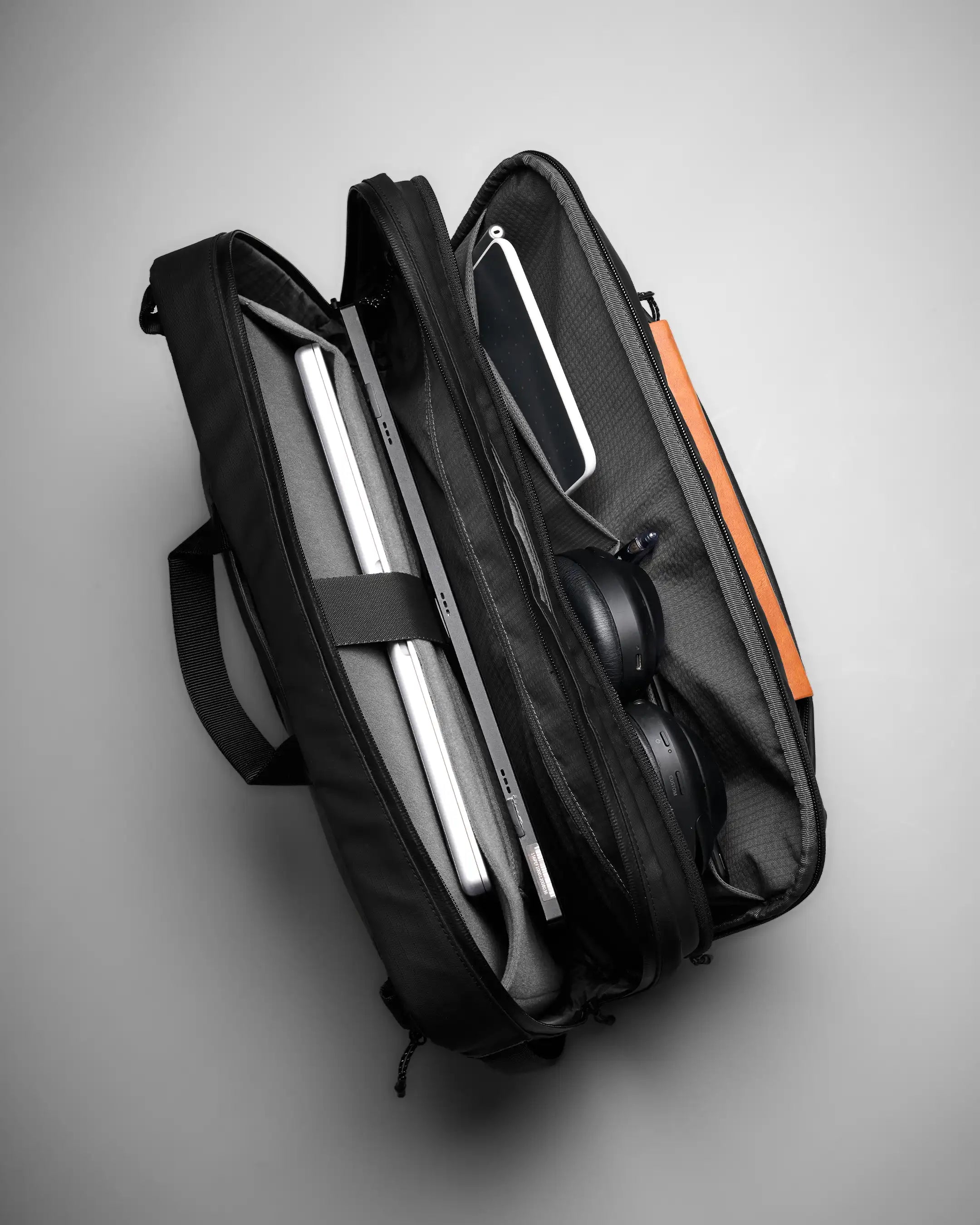Black briefcase with a laptop inside on a gray background