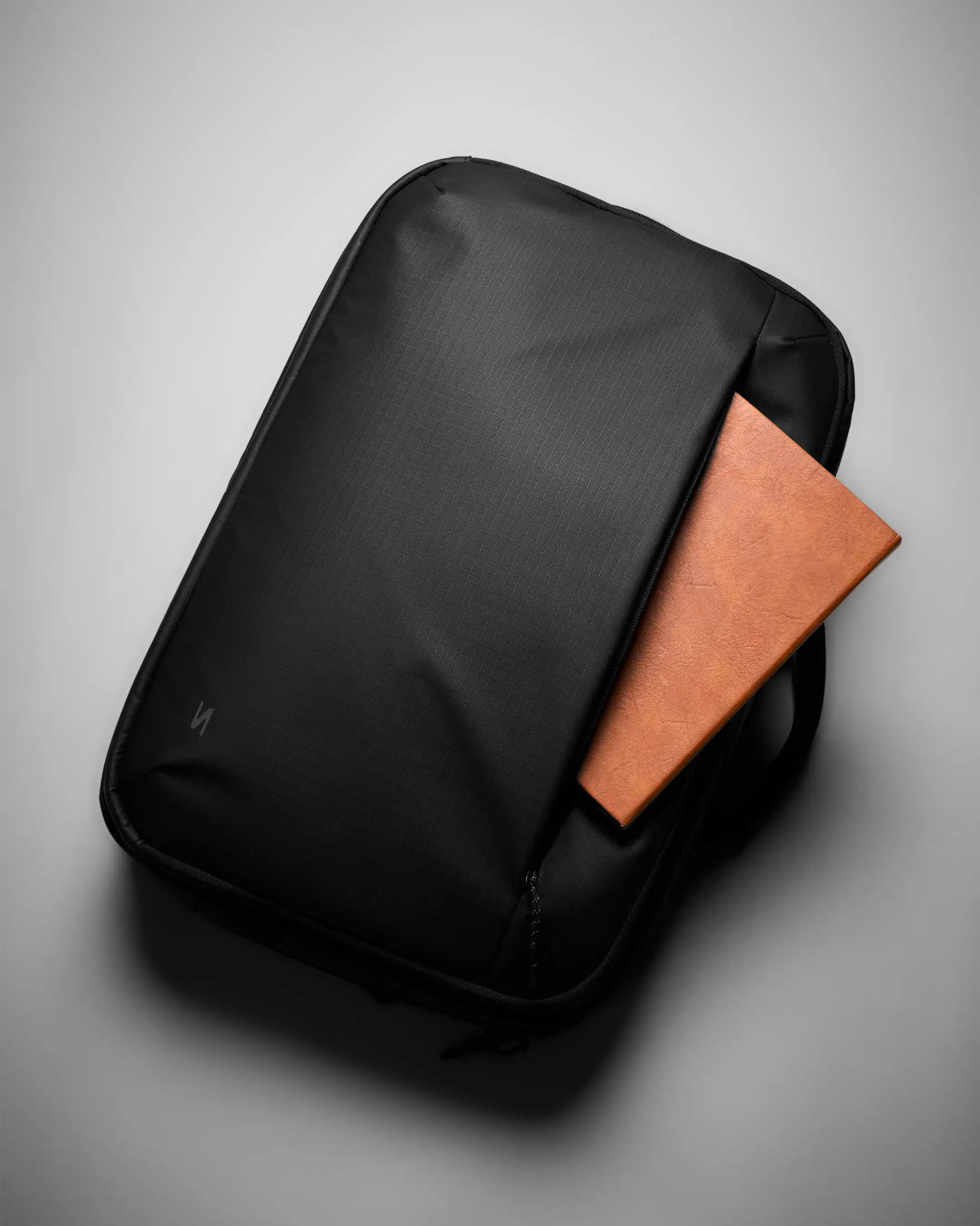 Black backpack with a brown interior on a gray background