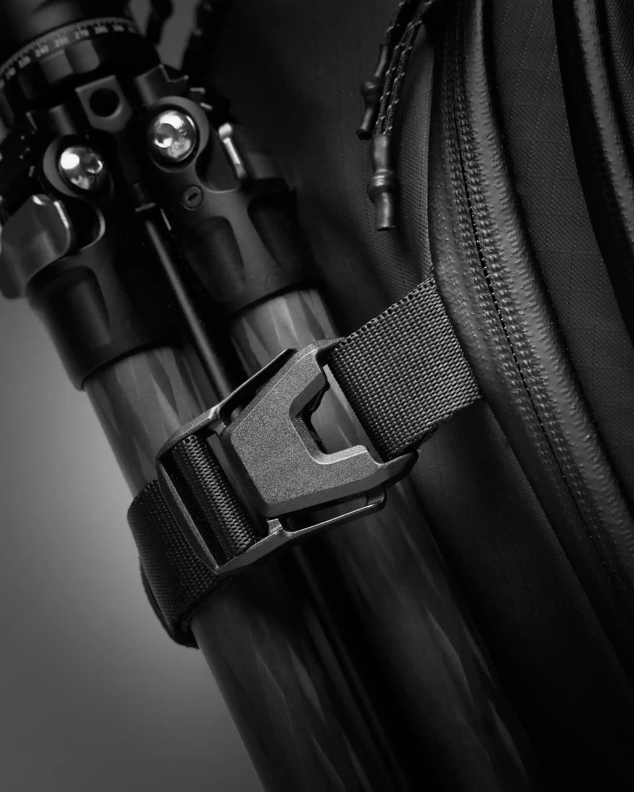 Close-up of a black backpack with a strap detail on a dark background