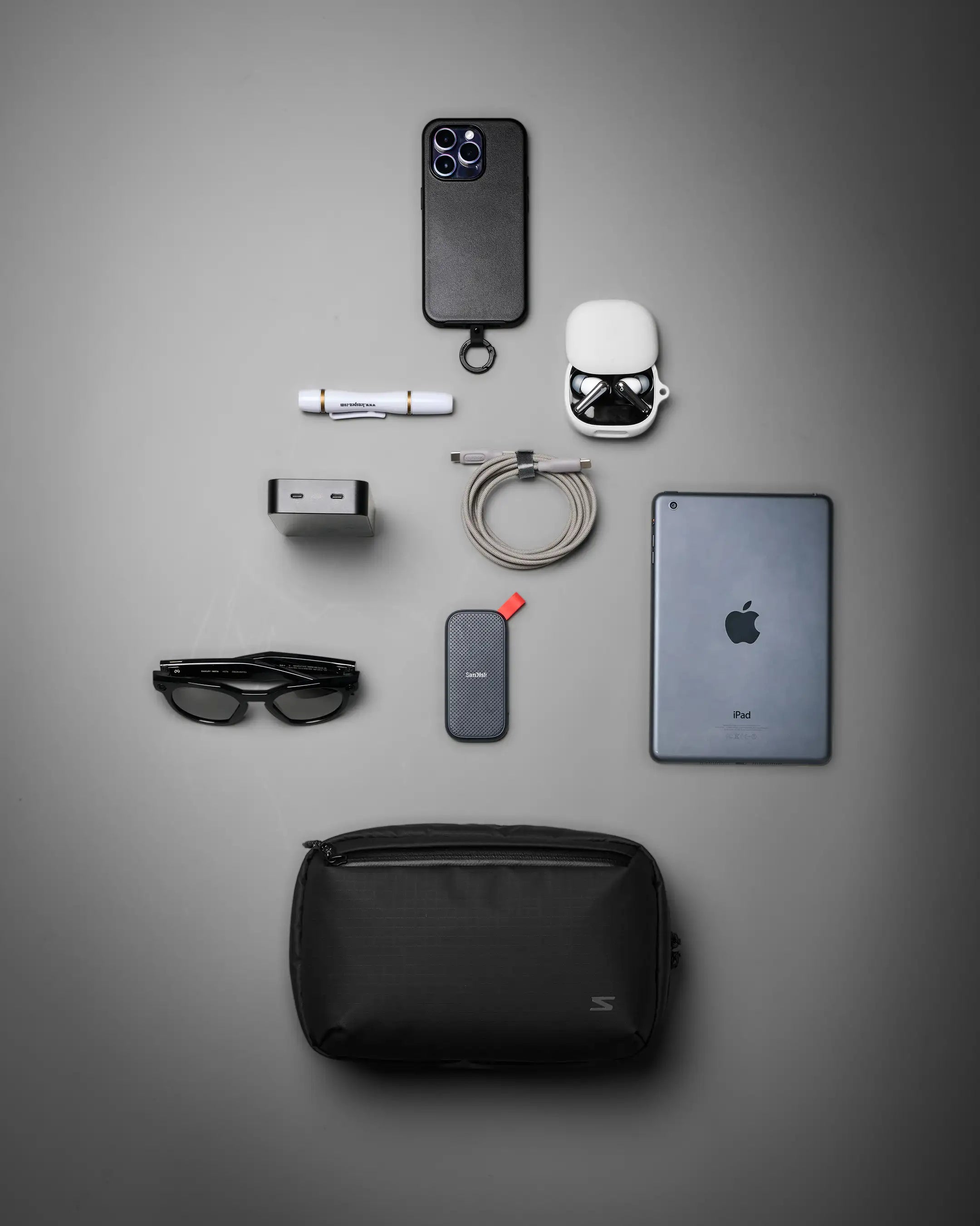 Collection of electronic devices and accessories on a gray background