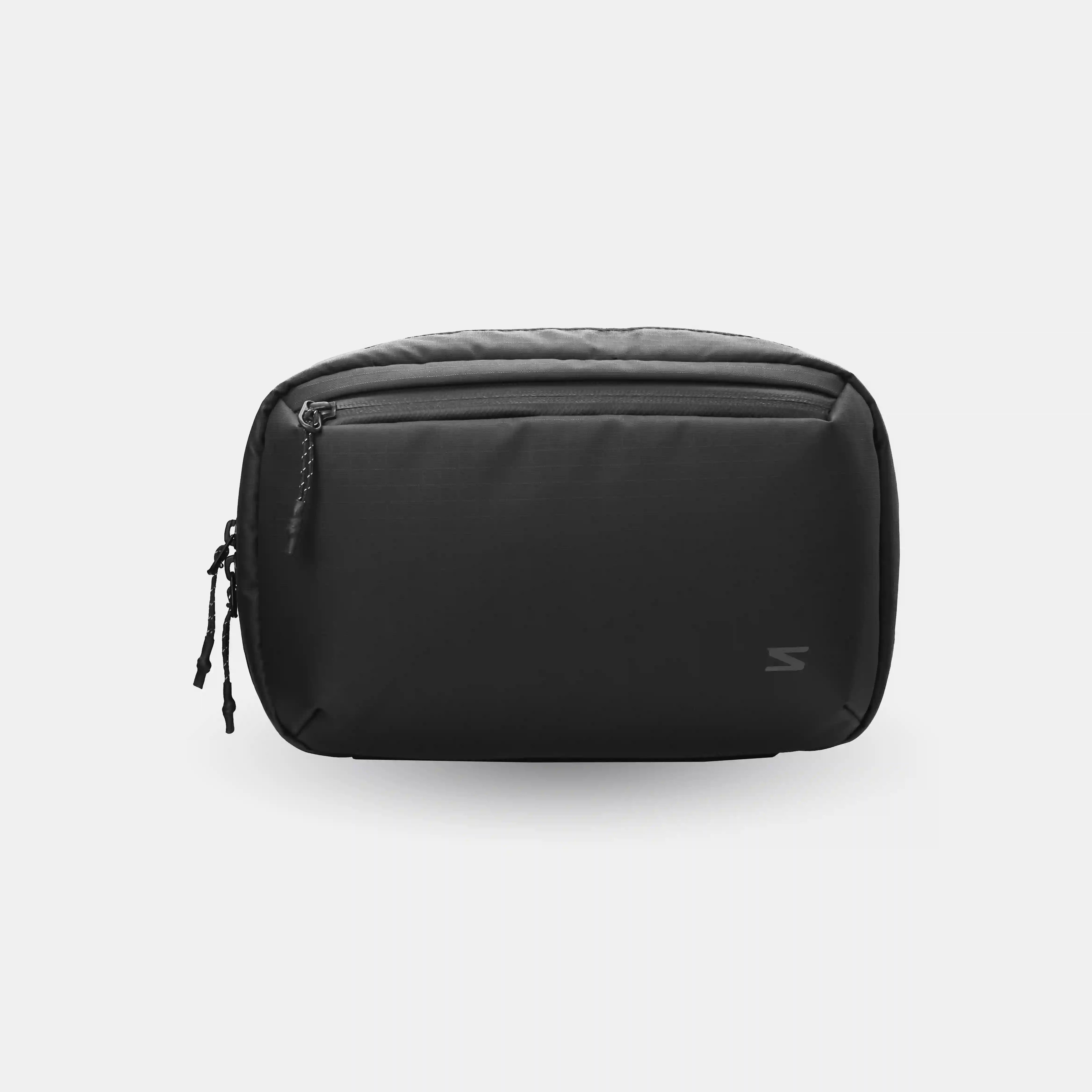 Black toiletry bag on a light gray background