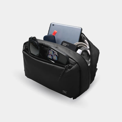 Black travel organizer with electronic devices on a light gray background