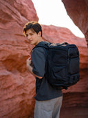 Camera bag packed for full-day shoot. Holds Canon 5D, prime lenses, tripod, and hoodie.
