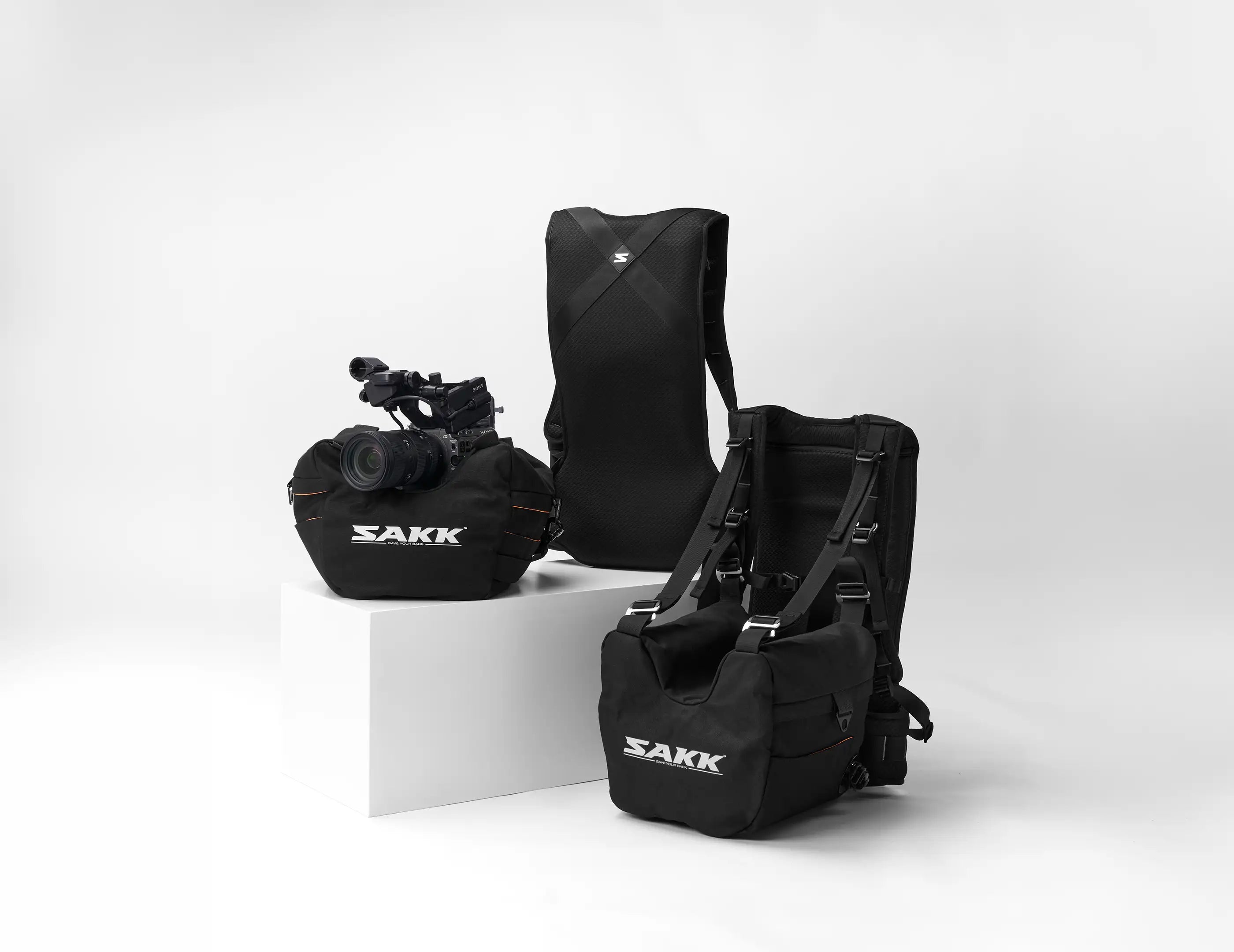 Black SAKK bags and camera on a white background