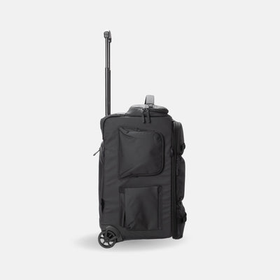A black rolling duffel bag with an extended telescoping handle, shown from a three-quarter side view against a light gray background.