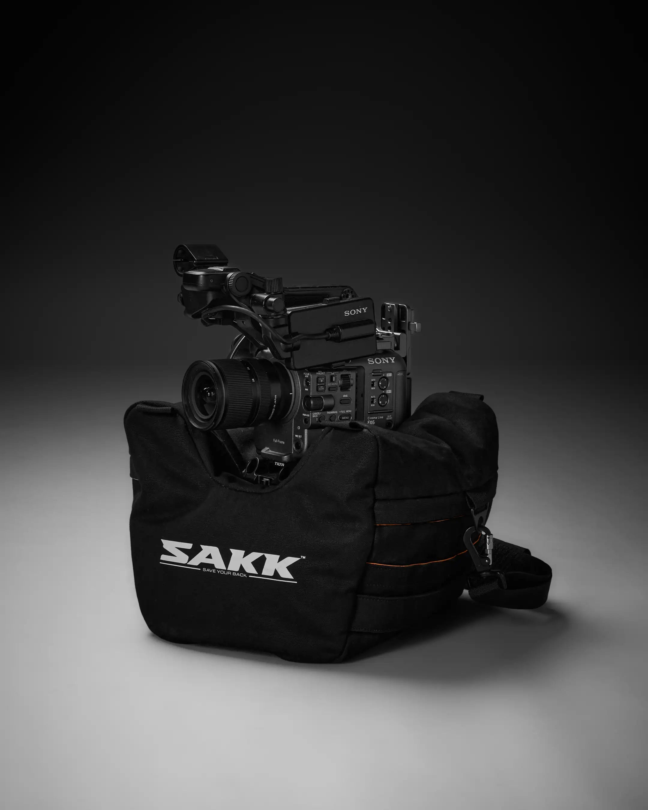 Camera in a black carrying case with 'SAKK' branding on a gray background