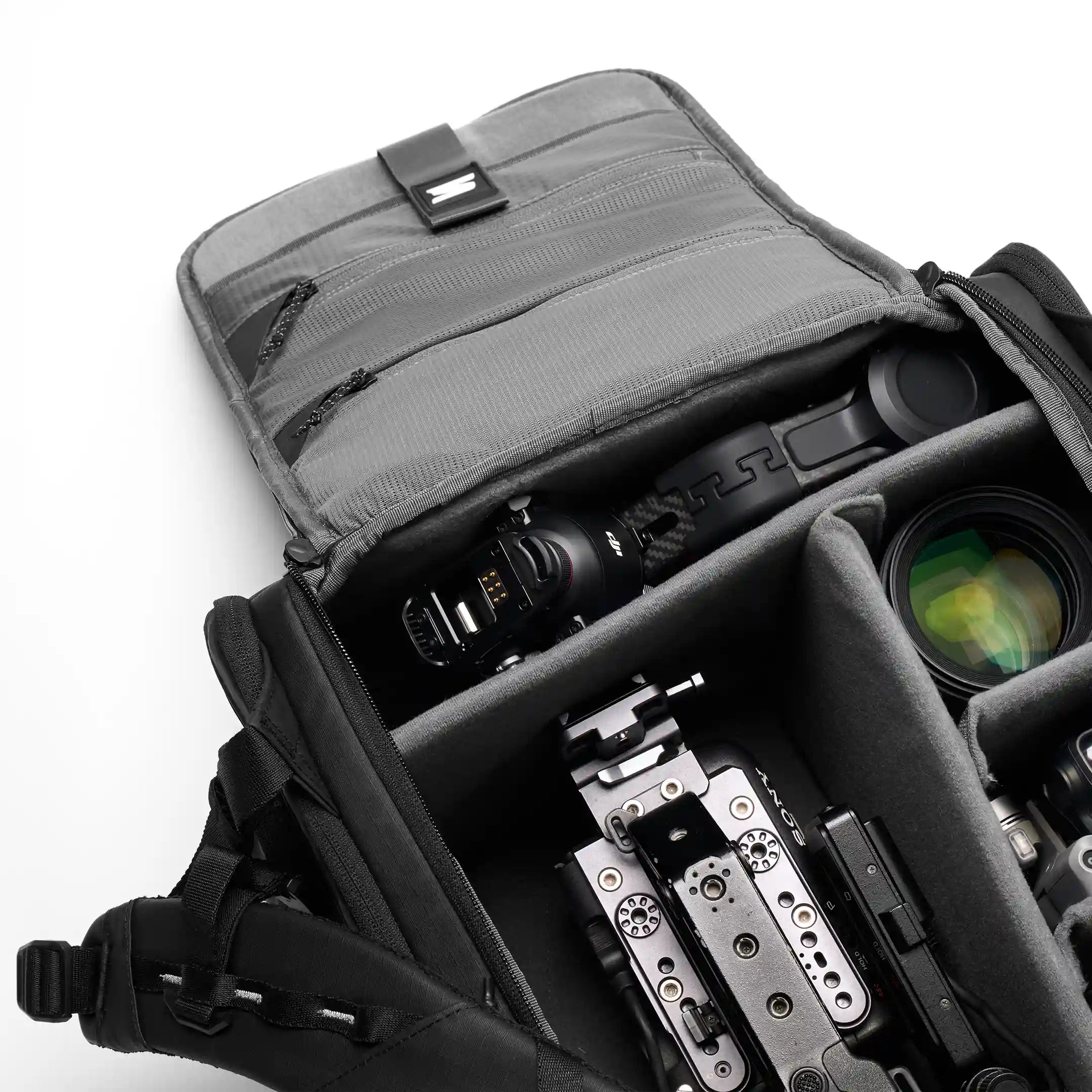 Camera equipment in a gray backpack on a white background