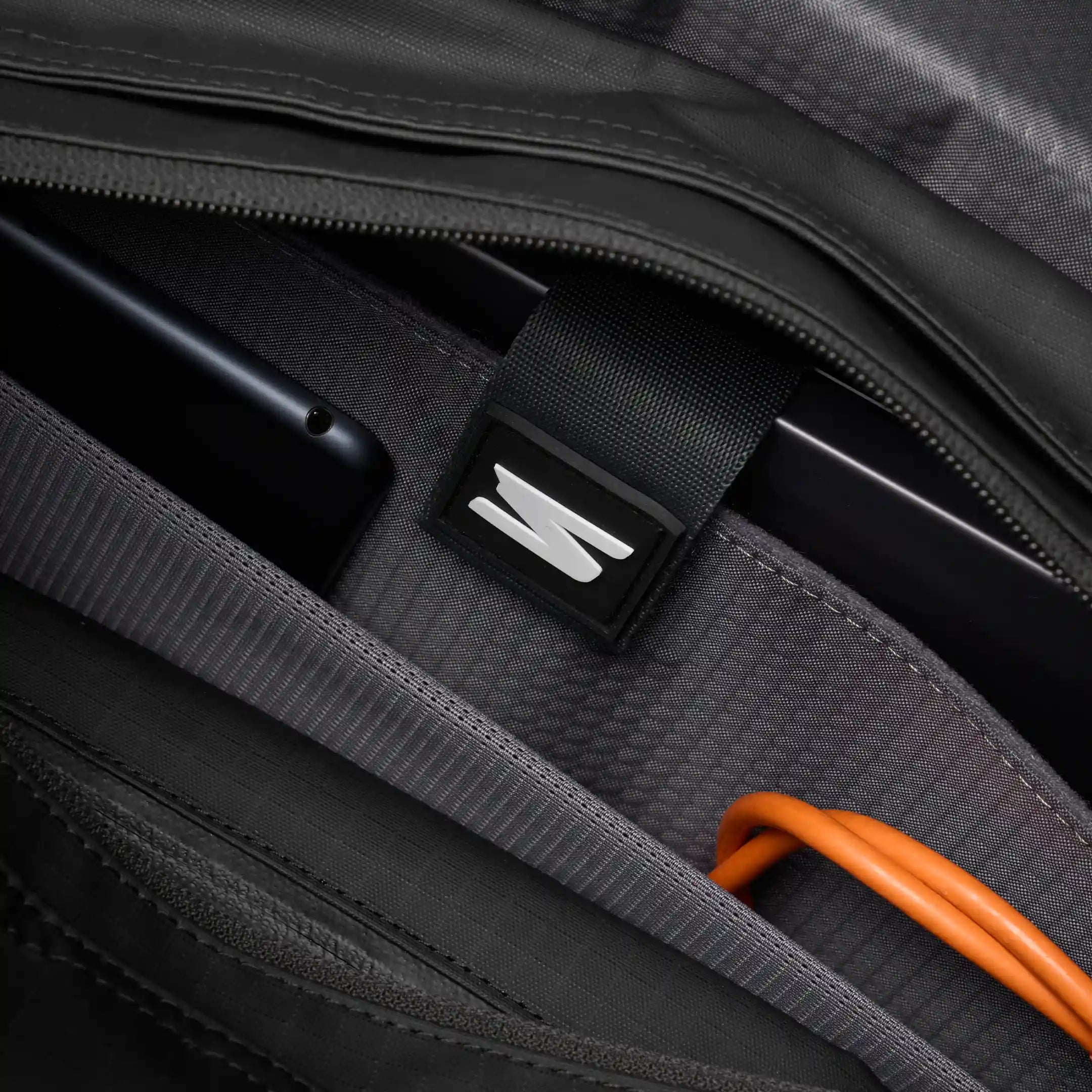 Close-up of a suitcase with a brand logo on a dark background
