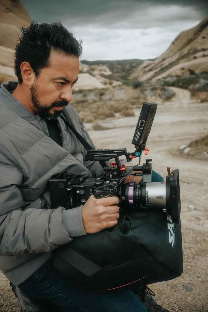 Man operating a professional camera using a saddle bag