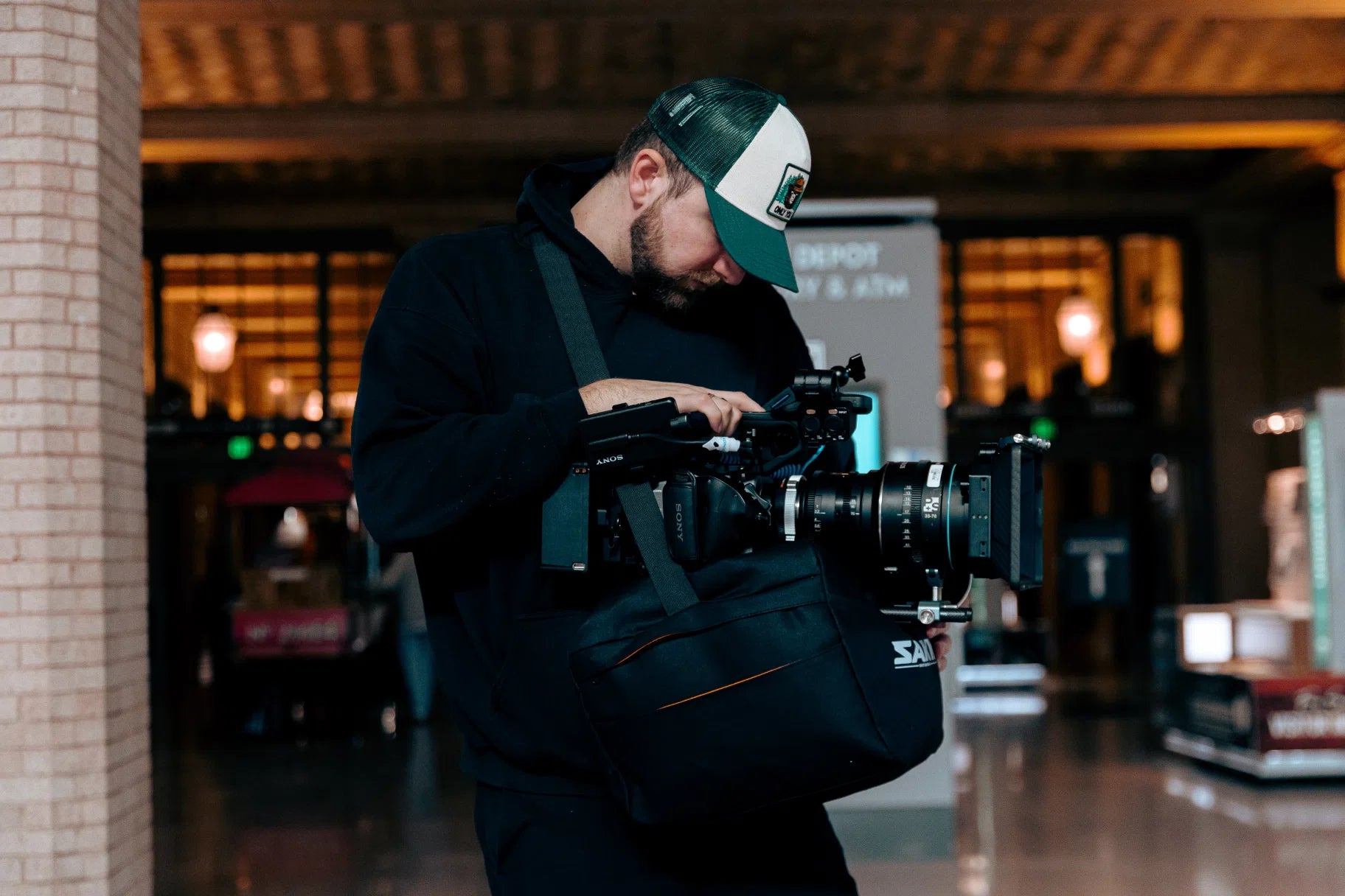 Person holding a camera in an indoor setting with a camera stabilizer