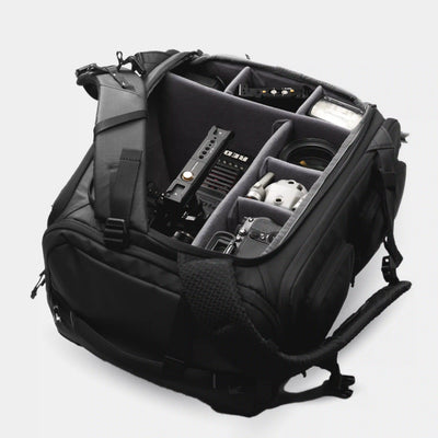 Black backpack with compartments and equipment on a white background