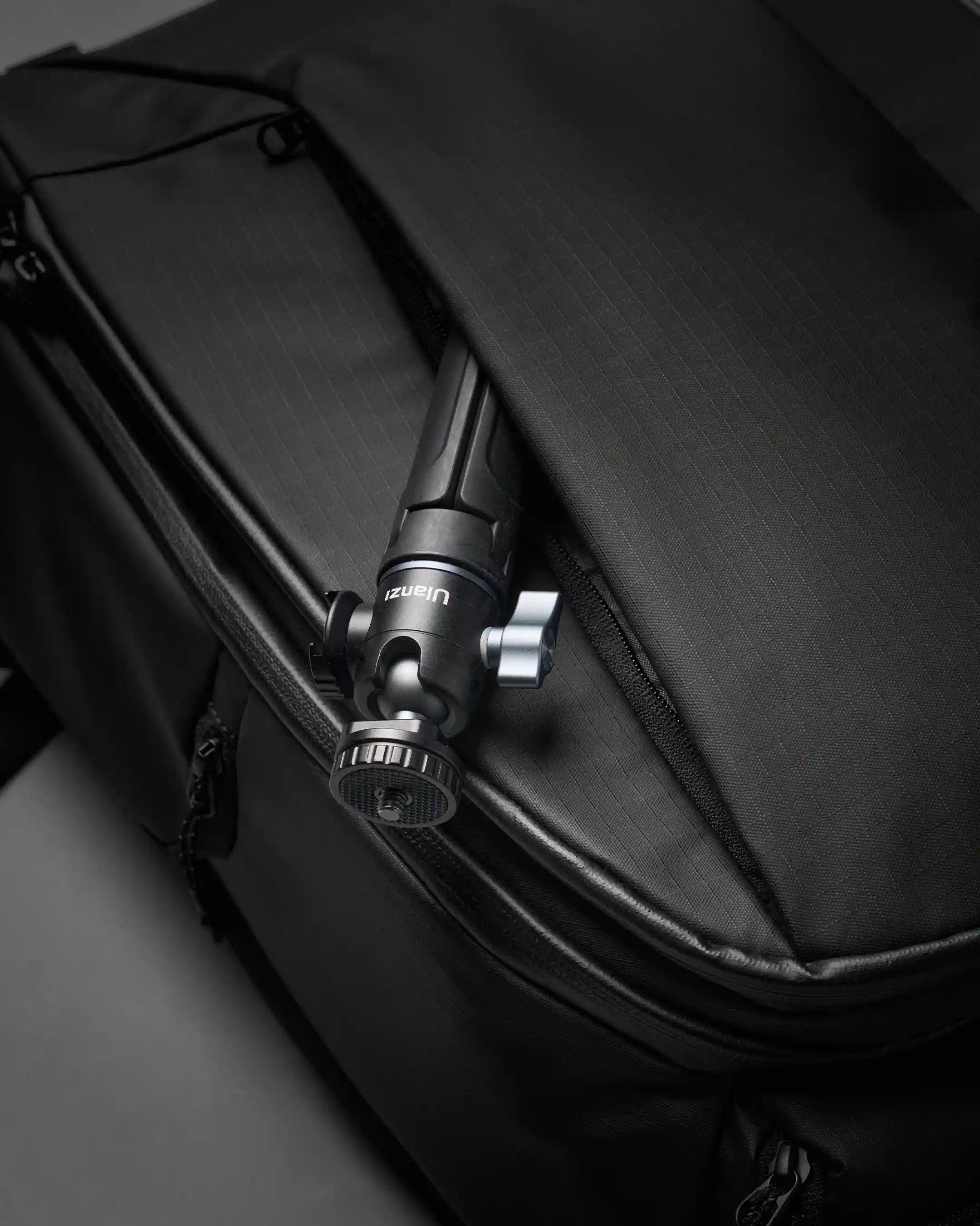 Black backpack with a camera mounted on a gray surface