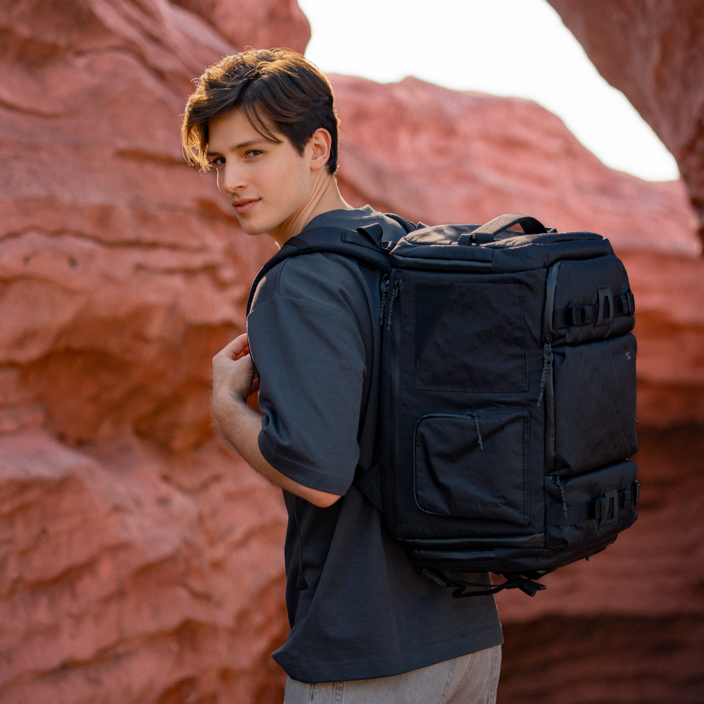Camera bag packed for full-day shoot. Holds Canon 5D, prime lenses, tripod, and hoodie.