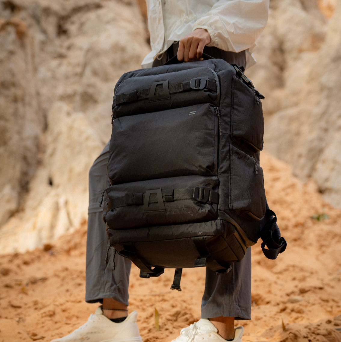 Reinforced nylon handle for overhead grabbing. Durable for airport-to-set transitions.