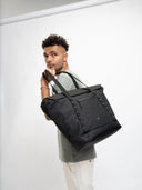Everyday Creator Tote carried on city streets with personal items and tech essentials inside.