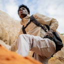 Built for movement—camera backpack worn during a climb, showing secure fit and all-day comfort in rugged terrain.