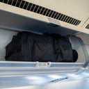 Sakk Pack Cube stored in airplane overhead cabin. Fits cinema cameras, laptop, and travel essentials for professional creators.