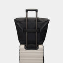 Travel-ready tote bag for creators, slipped onto carry-on luggage handle for easy mobility.